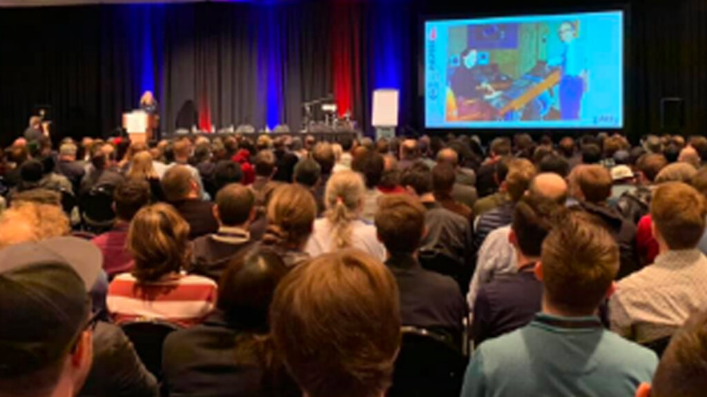 Sitting crowd watching video on screen